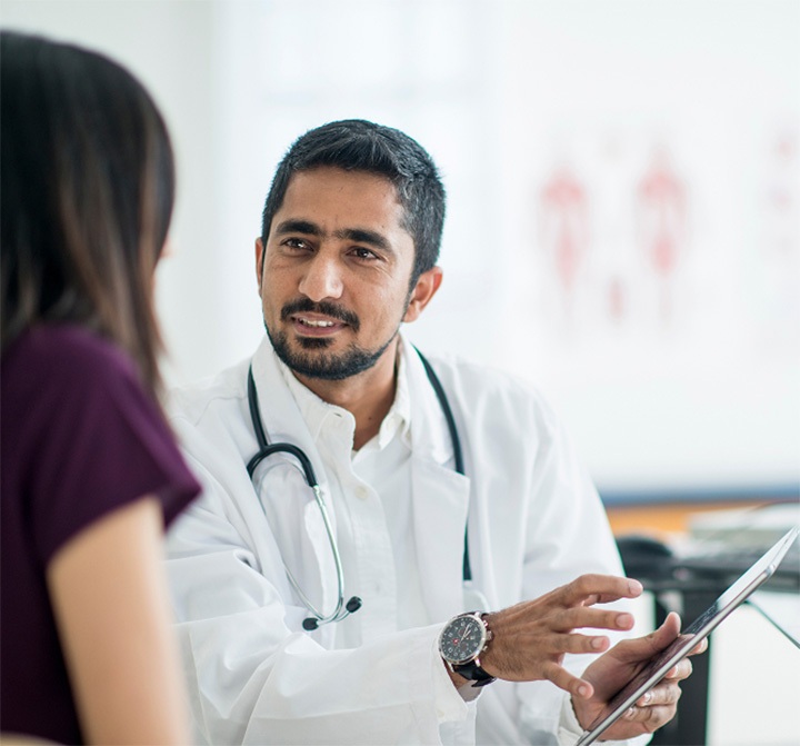 heartflow physician with patient, showing plaque analysis on tablet screen.